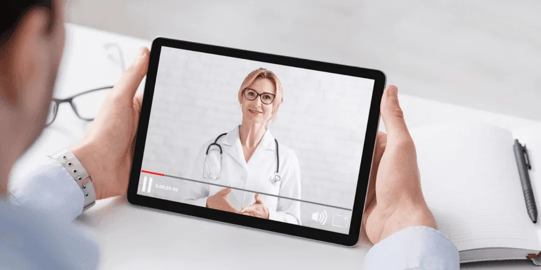 Tablet ekranında hastalara bilgi veren bir doktorun video görüntüsü